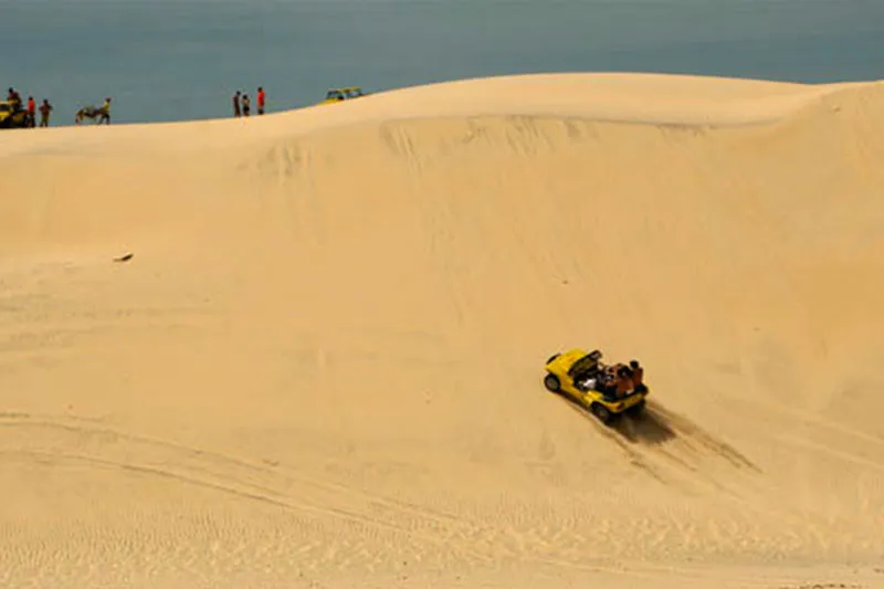 Buggy nas dunas do Cumbuco com lagoa ao fundo, em Caucaia, no Ceará